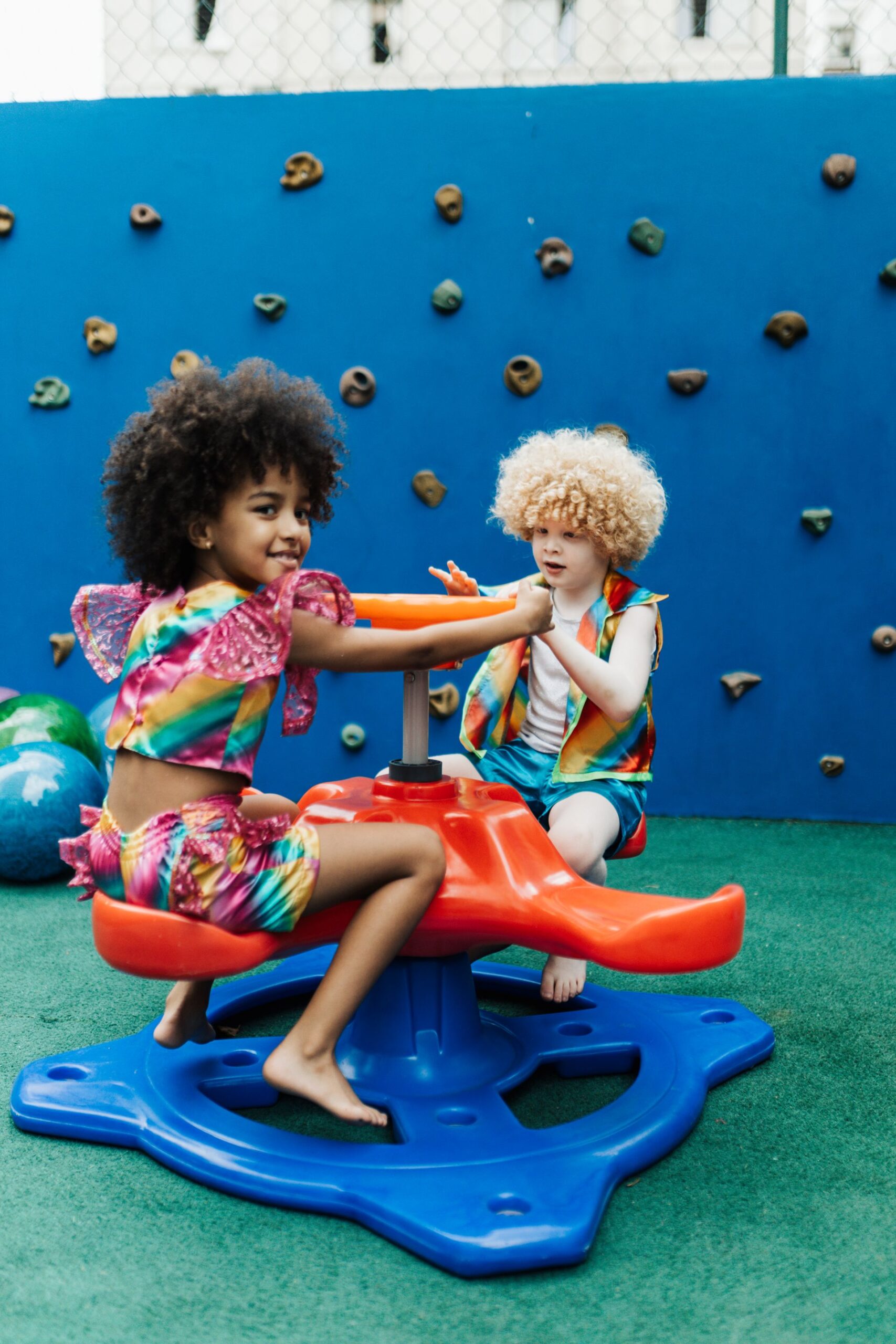 Children climbing a playground rock wall