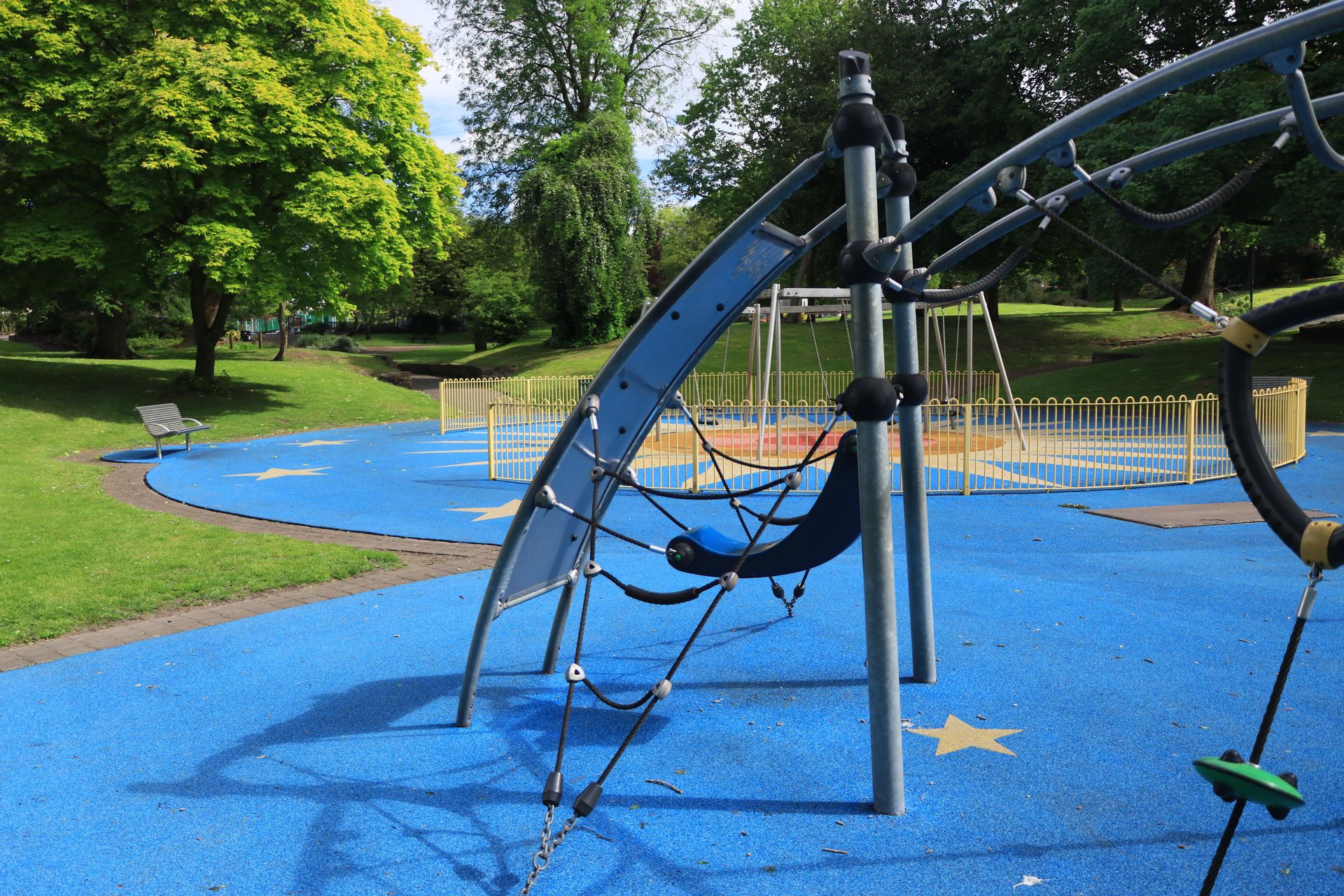 Commercial playground structure on blue poured-in-place safety surfacing